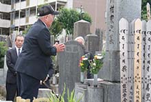 川村和太郎社長の墓前で手を合わせる島田良三氏の写真