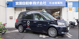 営業所出口に濃藍色のジャパンタクシーが止まっている写真