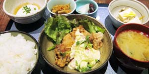 主菜を中心にご飯と味噌汁、小鉢が4つ並んだ定食の写真